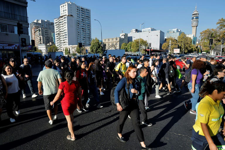 La gente camina por la Avenida Alameda durante un apagón en Santiago el 25 de febrero de 2025