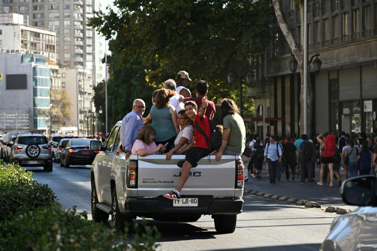 Pessoas lotam uma caminhonete durante o apagão, em Santiago