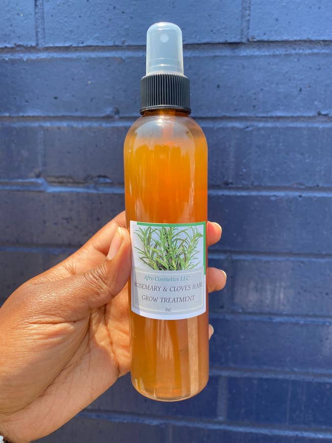 A hand holds a bottle labeled