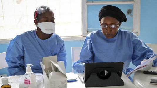 Two WHO aid workers prepare to vaccinate other health workers from the DRC, suspected of being infected with the ebola disease, Wednesday, May 30, 2018, in Mbandaka, Congo.