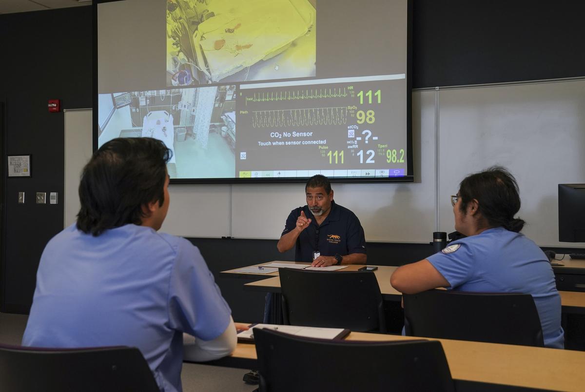 Victor Garza III, MSN, RN and an instructor at South Texas College, goes over the notes with students related to the simulation. Credit: Gabriel V. Cárdenas for The Texas Tribune