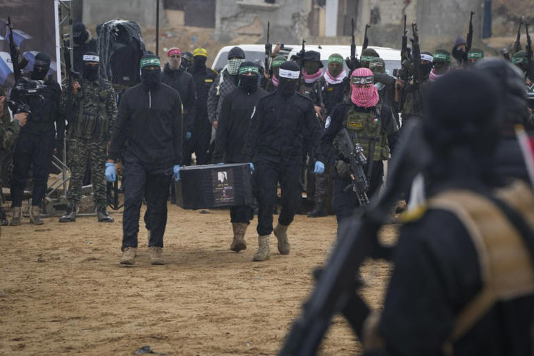 Militants carry a coffin bearing a photo of Israeli hostage Shiri Bibas during the handover in Khan Younis, Gaza.