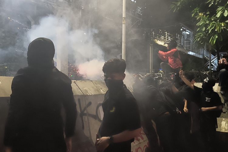 Peserta aksi Indonesia Gelap menghidupkan bom molotov ke arah polisi.