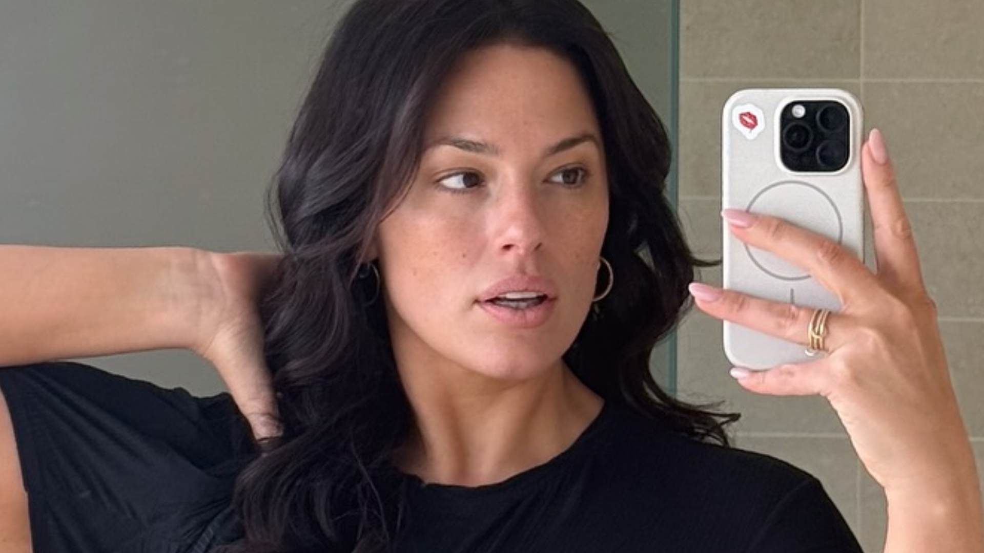 In a satin outfit, plus-size model Ashley Graham showcases her figure
