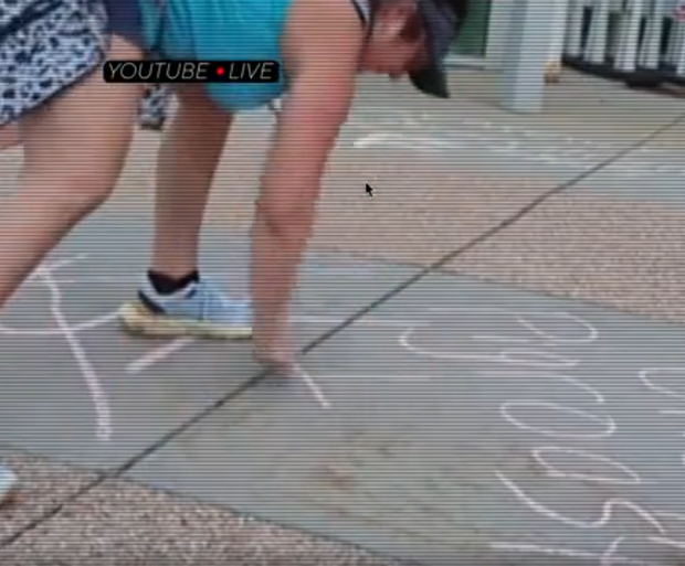 This image from Regan Benson's livestream outside Denver Police Department's District 3 station shows the writing Benson left in chalk. Regan Benson