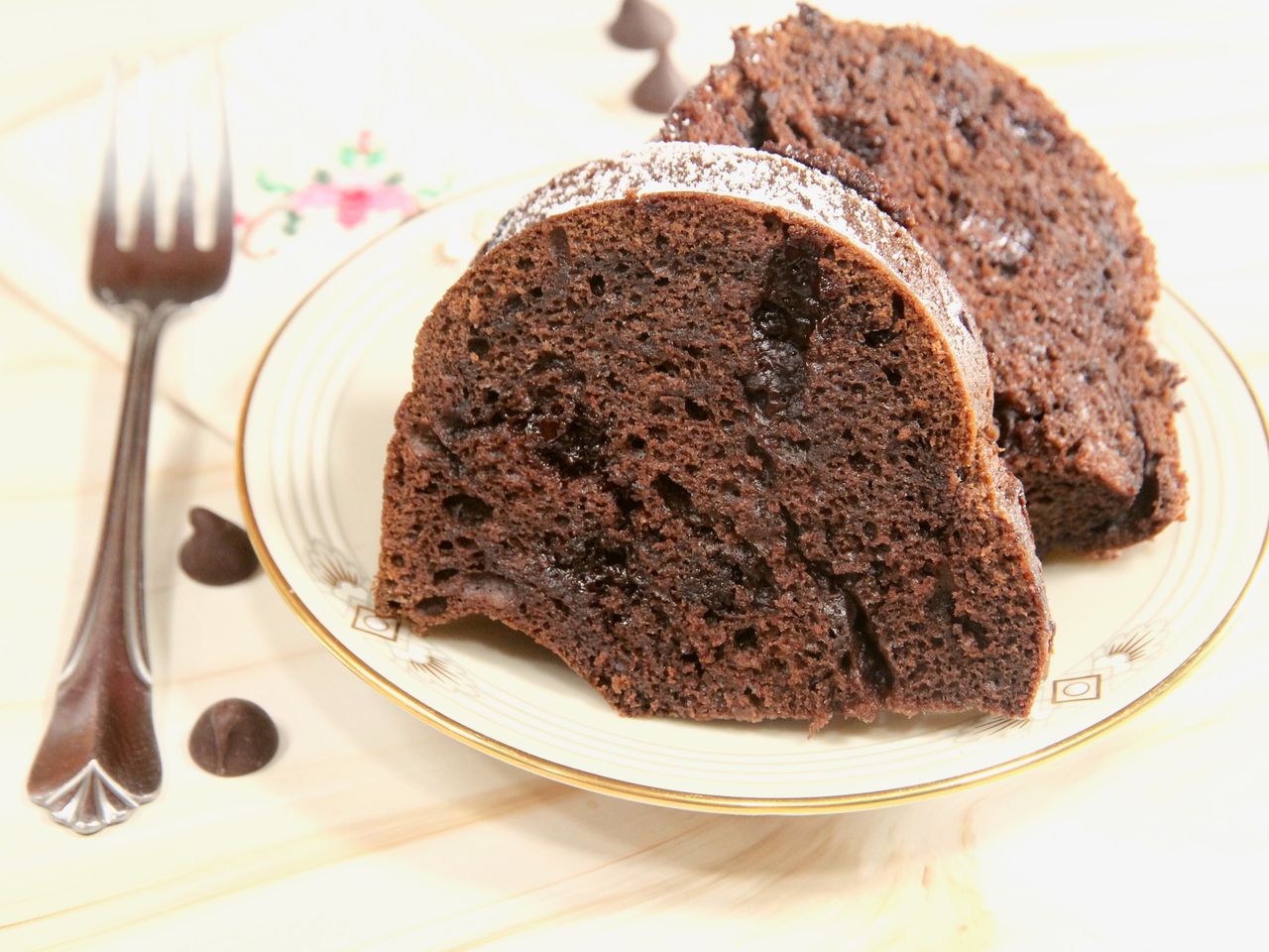 2 slices of chocolate brownie cake on plate with gold rim