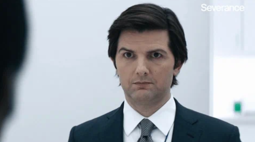 Man in suit with serious expression in an indoor setting. White background with the word "Severance" in the corner