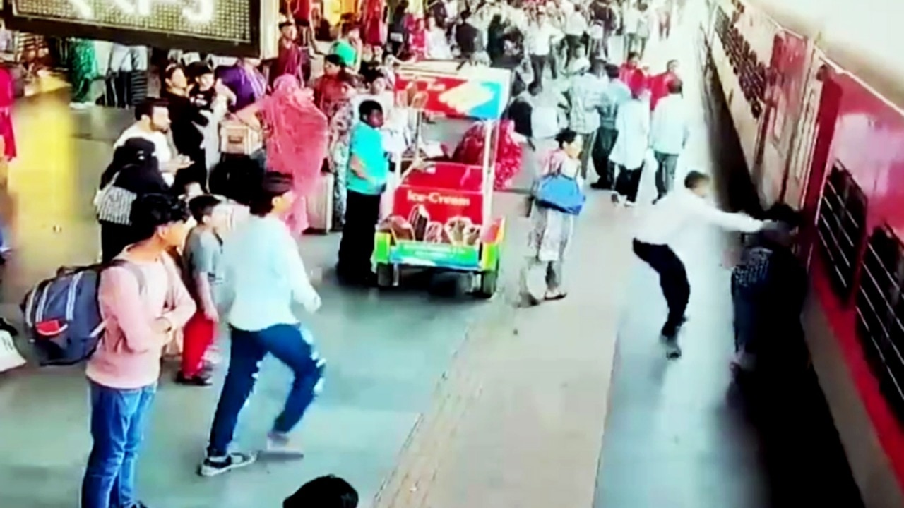 Video: Cops save woman from falling under moving train at Surat railway ...