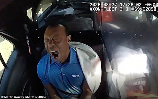 Woods yawns in the back of the police car on his way to jail in Florida last Friday