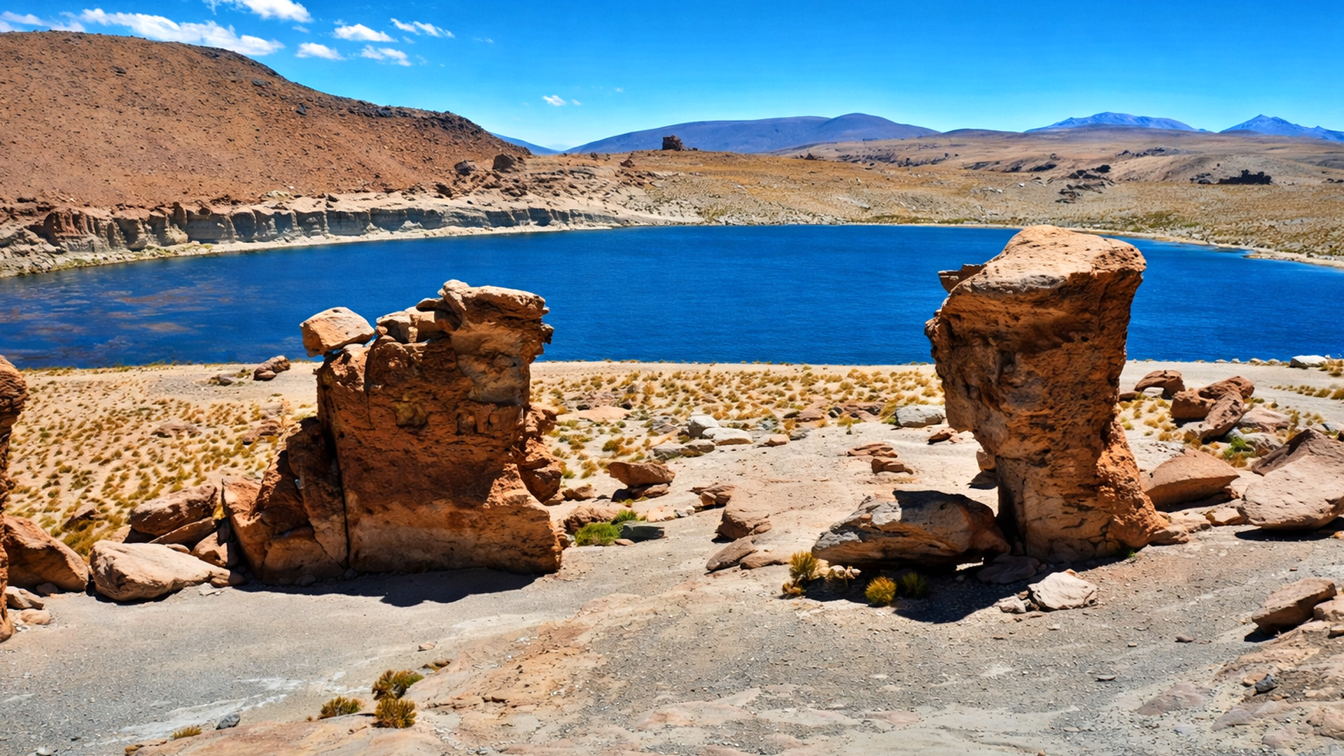 Rock formations at Laguna Turuiri with a blue lake in the desert