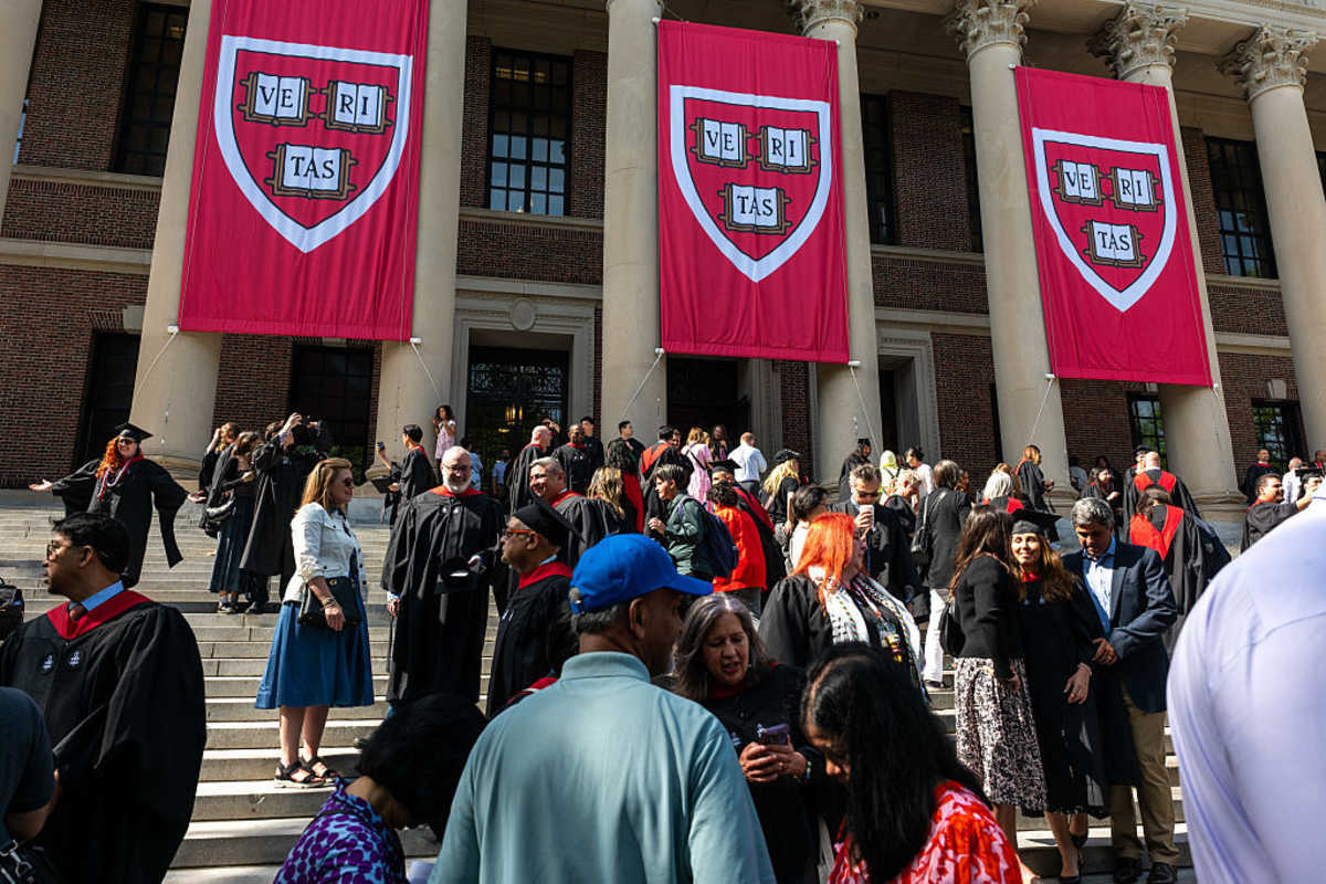 Graduation students, faculty, and family gather in Harvard Yard on May 28, 2025 in Cambridge, Massachusetts. As President Donald Trump intensifies his fight with the nation’s oldest and one of the world’s wealthiest universities, his administration has asked federal agencies on Tuesday to cancel contracts with Harvard University valued at approximately $100 million (Spencer Platt/Getty Images)