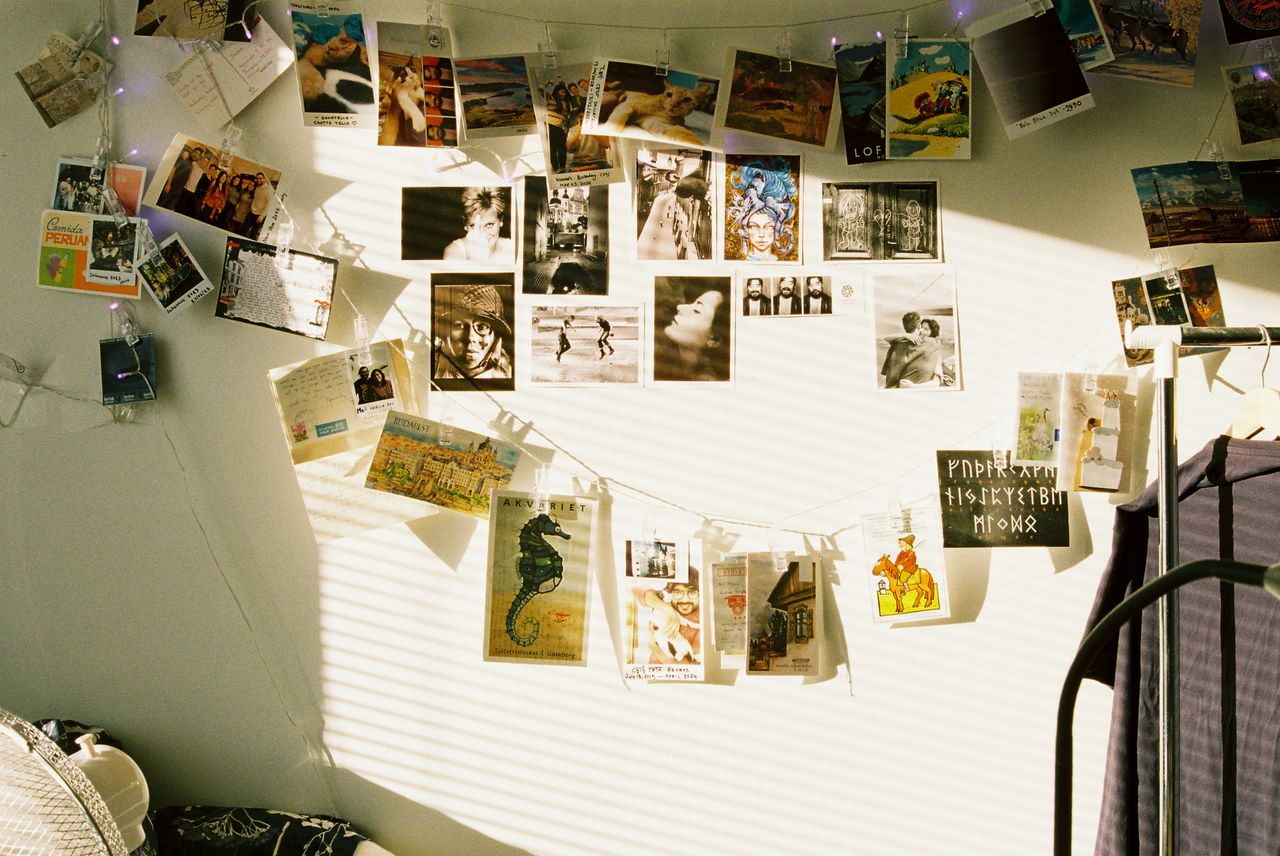 Vintage postcards hanging up on a wall over a bed