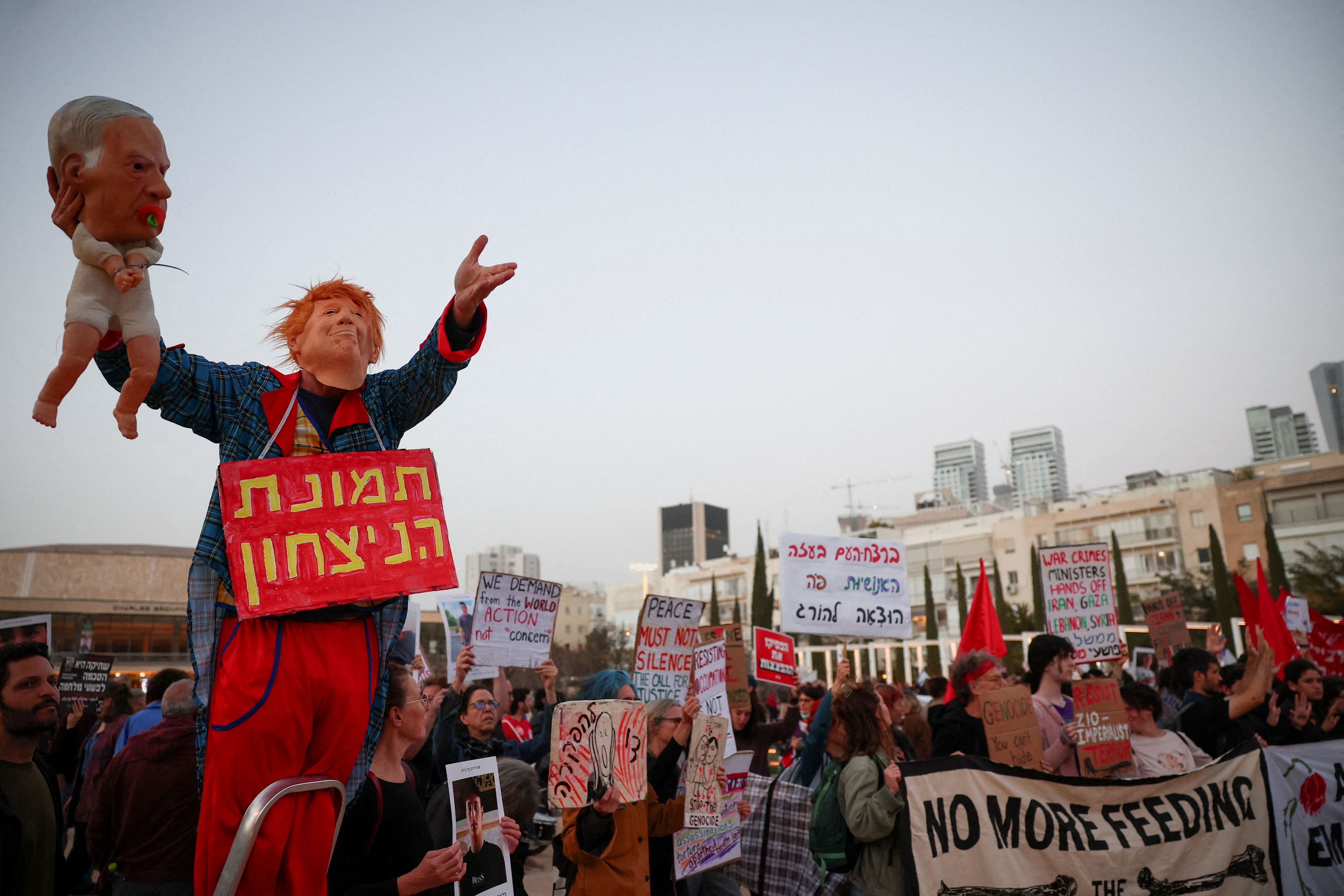 A demonstrator wears a mask depicting U.S. President Donald Trump while holding a puppet of a baby with a mask depicting Israeli Prime Minister Benjamin Netanyahu during an anti-war protest calling for an end to the U.S.-Israel conflict with Iran, in Tel Aviv, Israel, April 4, 2026.