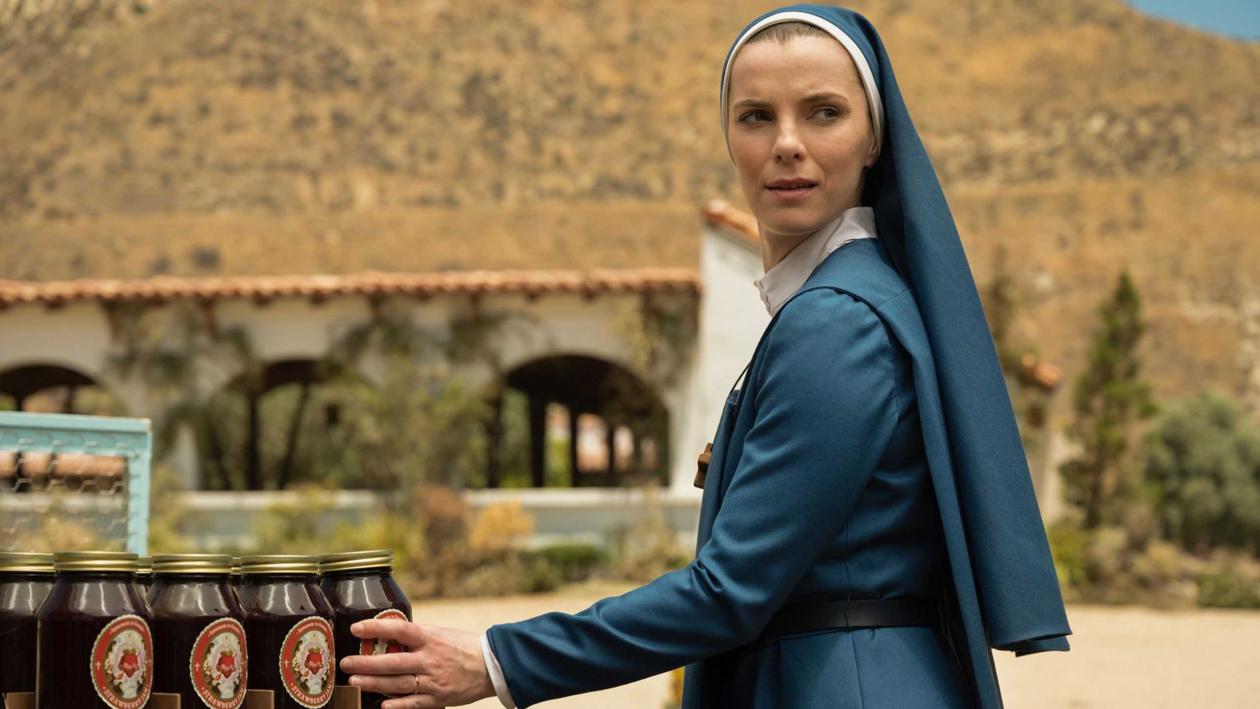 Sister Simone (Betty Gilpin) picking up a jar of jam in Mrs. Davis episode 1.