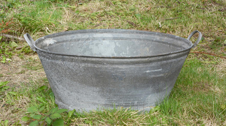 Turn a vintage wash bin into a rustic blanket storage solution