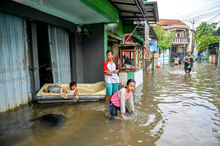 Aktivitas warga tetap berlangsung meski banjir melanda. Tampak warga masih berdagang meski banjir merendam. Foto: Raisan Al Farisi/ANTARA FOTO