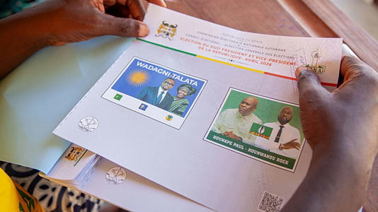 Un membre du personnel électoral prépare les bulletins de vote pour l'élection présidentielle dans un bureau de vote à Cotonou, au Bénin, le dimanche 12 avril 2026.