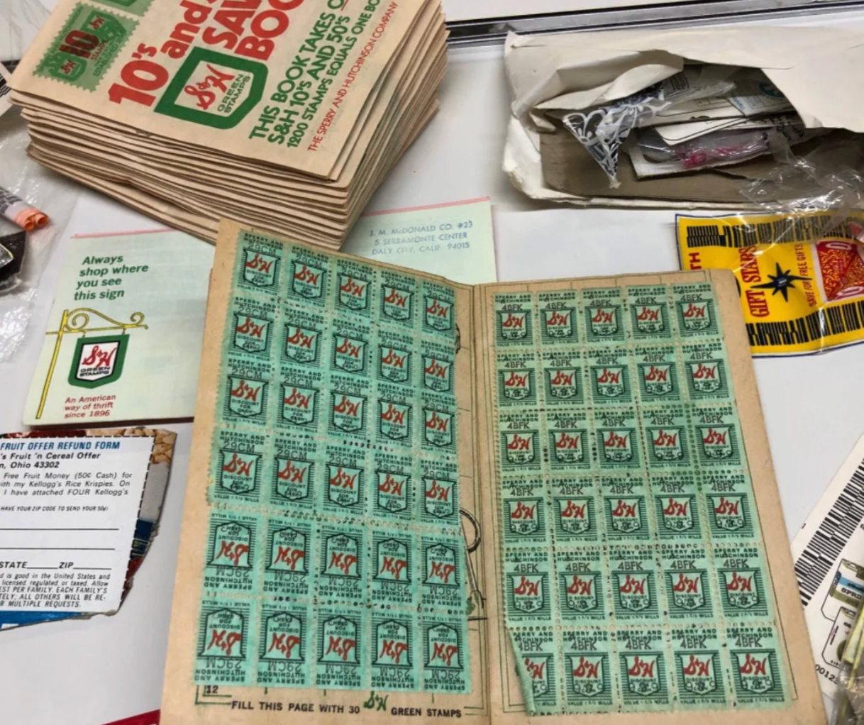 Reddit post showing S&H Green Stamps and a booklet. Caption explains their use in the 1980s for supermarket and store rewards