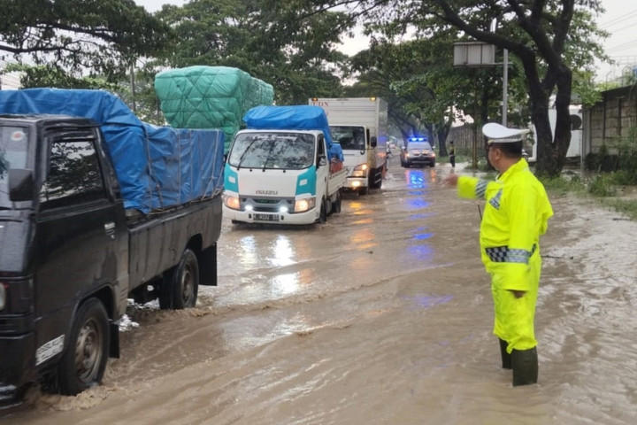 Polisi mengatur jalur lalul lintas banjir di jalan raya Kudus-Pati, Minggu (12/4/2026). Foto: Polres Kudus