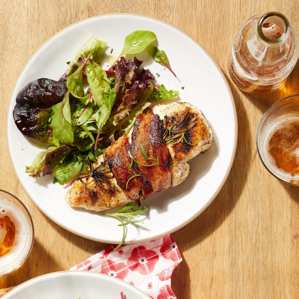 overhead view of Grilled Chicken with Rosemary and Bacon recipe served on a plate with mixed green salad