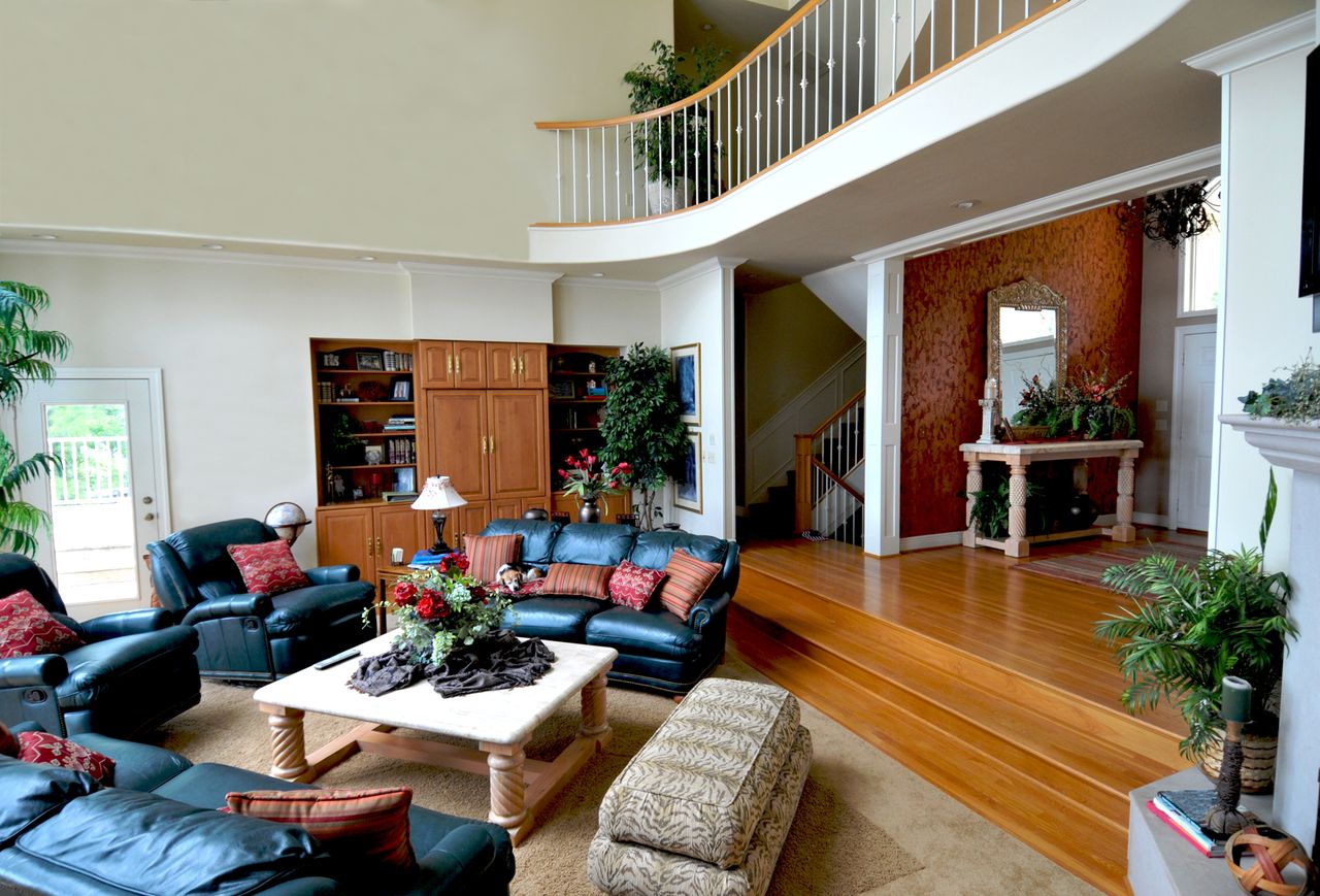 Sunken living room with black leather sofas and recliners