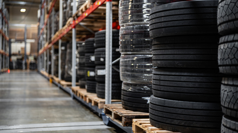 A lineup of showing various types of vehicle tires in a warehouse