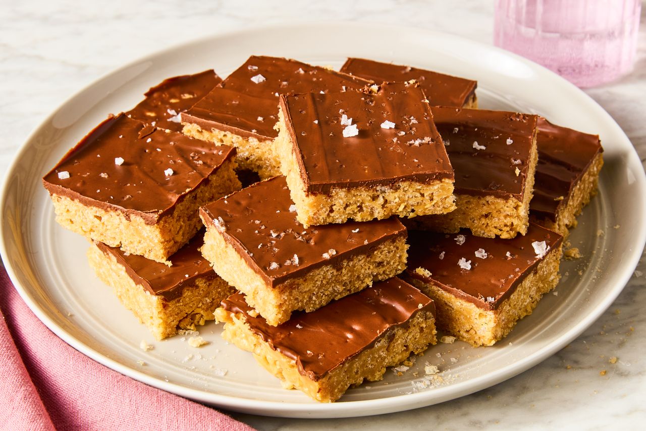 Angled view of sliced squares of Scotcheroos stacked on a plate