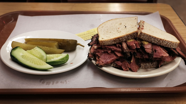 Pastrami on rye sandwich with pickles on the side from Katz's Deli