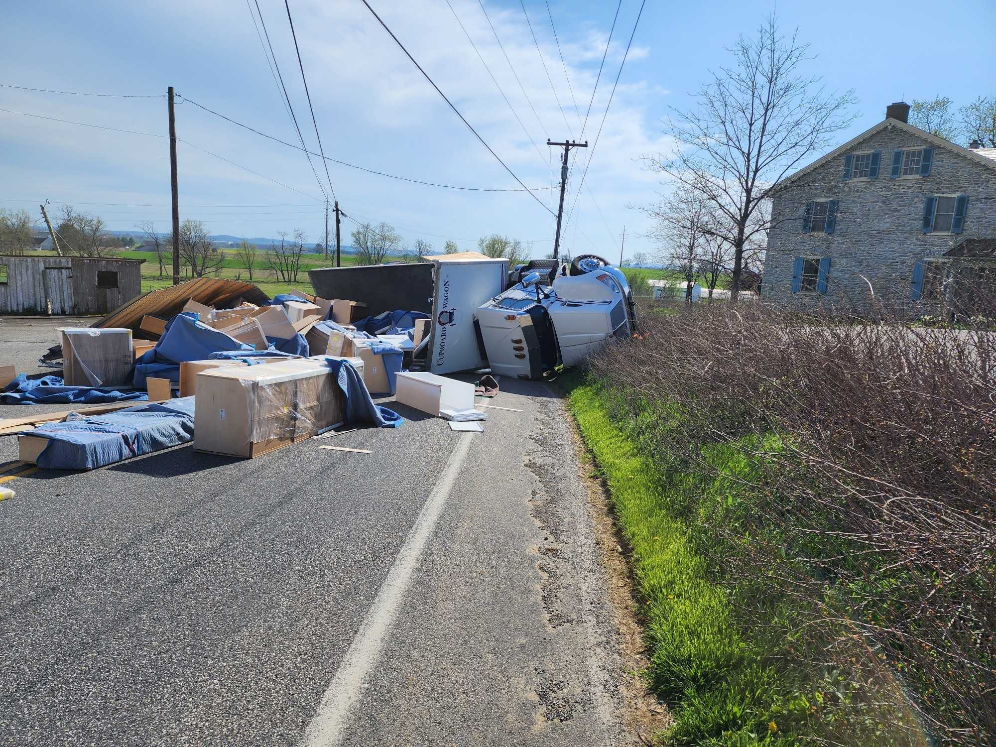 Box truck splits open, spilling cargo across road after crash