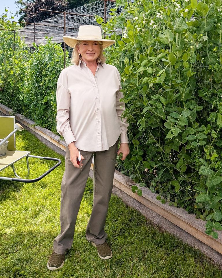 Martha Stewart standing outdoors near a garden bed