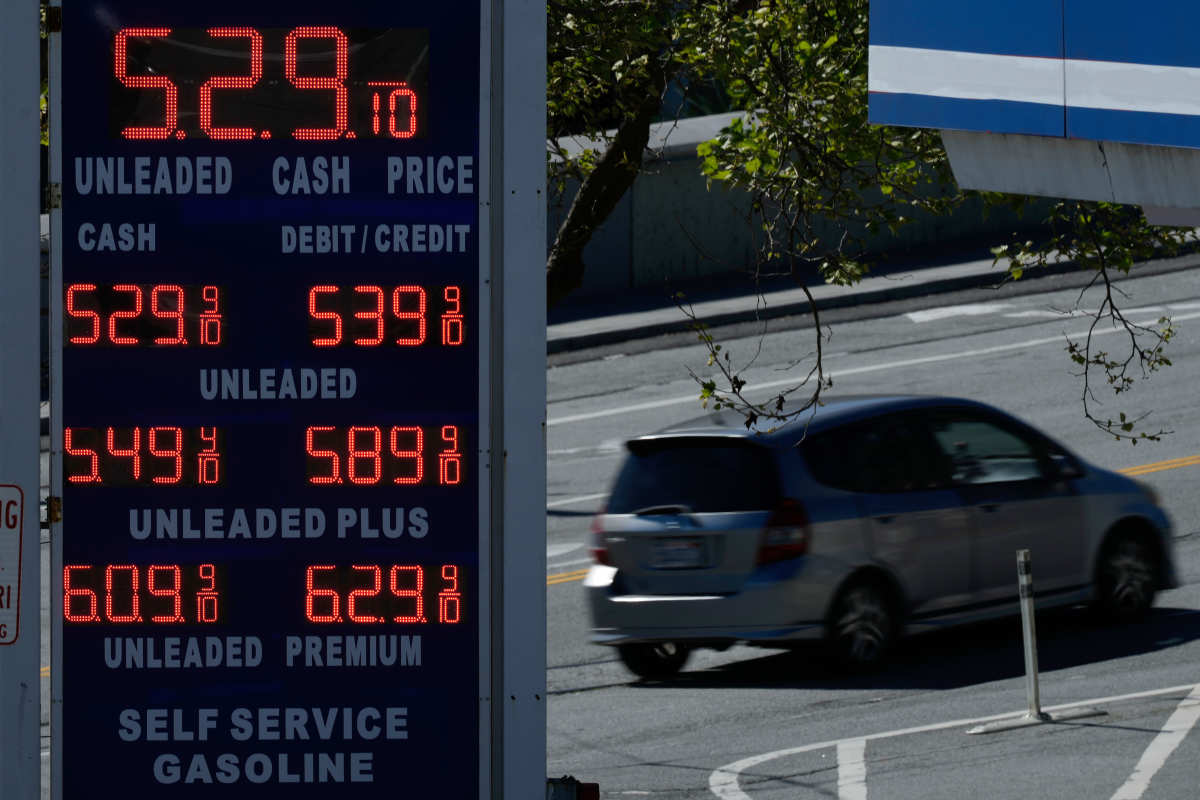 A car drives behind the gasoline price board of a gas station in San Francisco, Thursday, March 5, 2026. (AP Photo/Jeff Chiu)