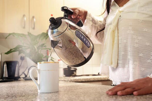 pouring water from kettle into mug