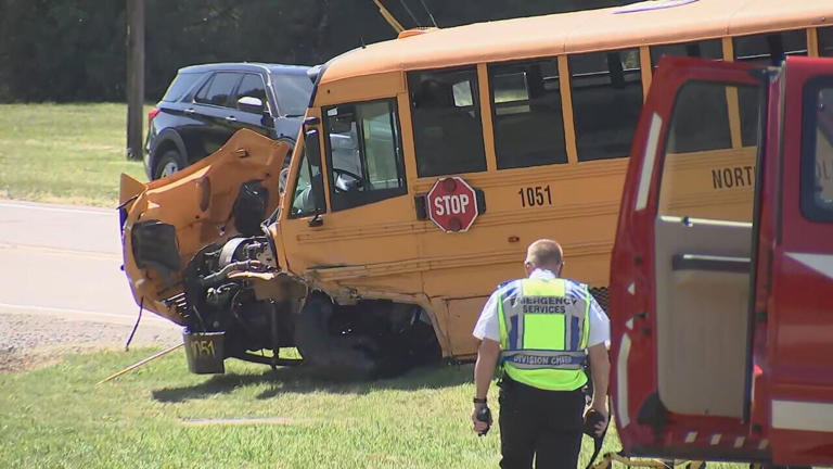Driver of government car charged after hitting school bus returning ...