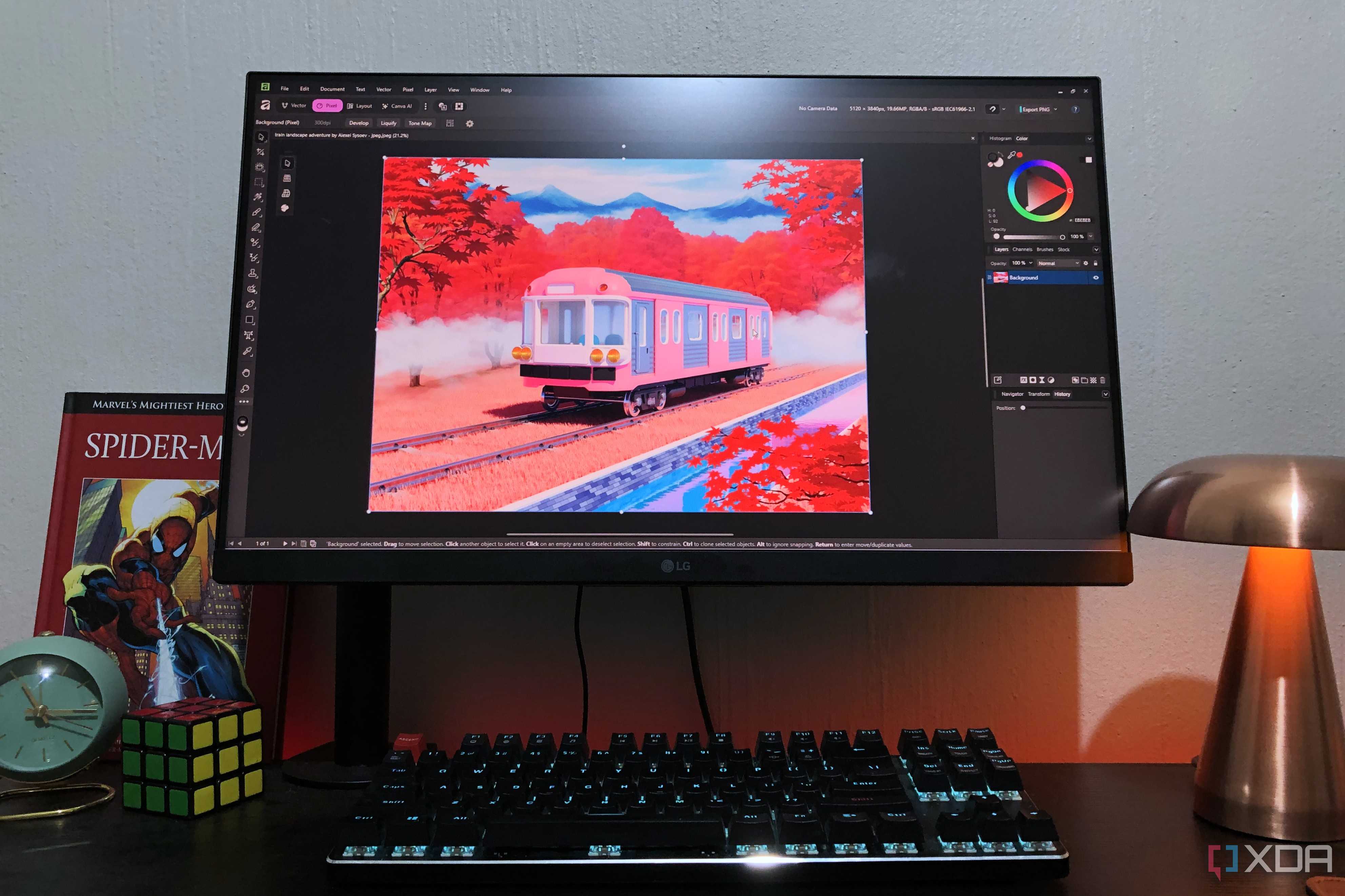 Affinity on desktop pc with train graphics, lamp and book in view