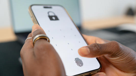A person unlocking their smartphone, with the option of either fingerprint or PIN
