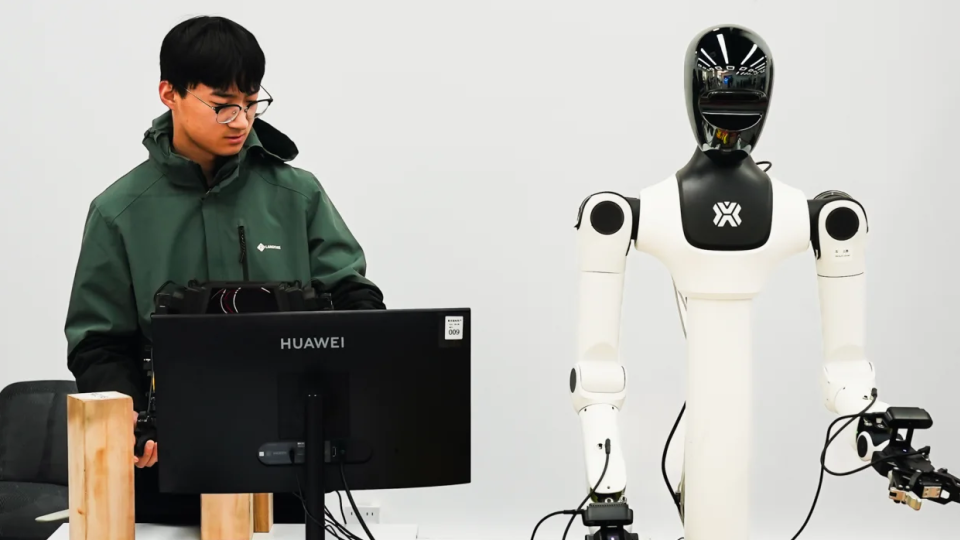 Se ve a trabajadores entrenando robots humanoides. Imagen tomada en el centro de entrenamiento de robots de X-humanoid, en las afueras de Beijing, el 19 de marzo. - Justin Robertson/CNN
