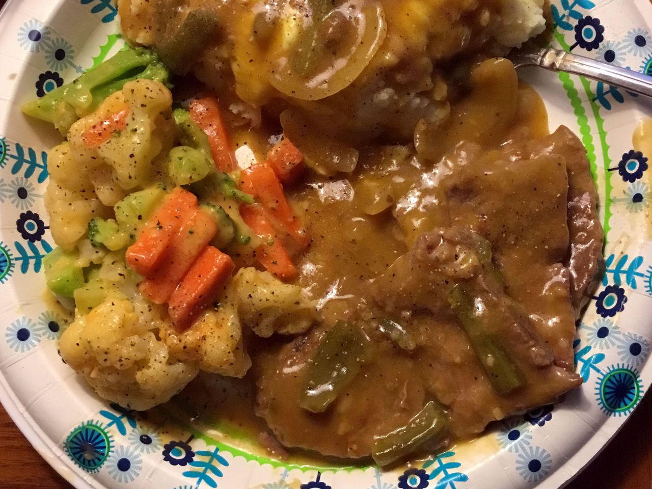 top-down view of a plate with mashed potatoes, gravy, Grandma's Slow Cooker Swiss Steak, and mixed vegetables