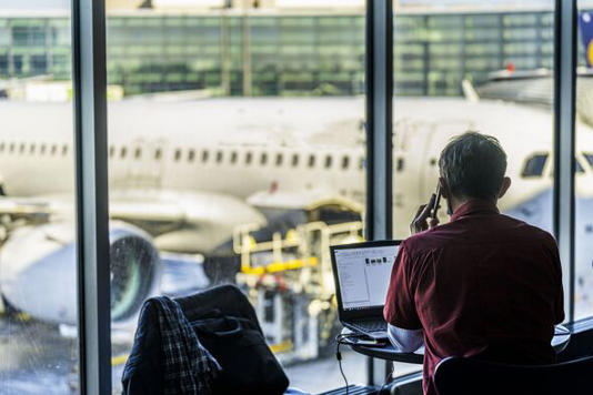 Businessman working on laptop in the airport lounge