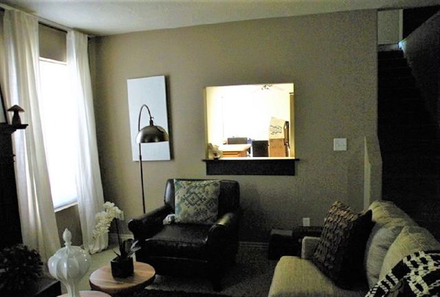 Dark and dreary living room with leather chair, lamp, and couch before makeover