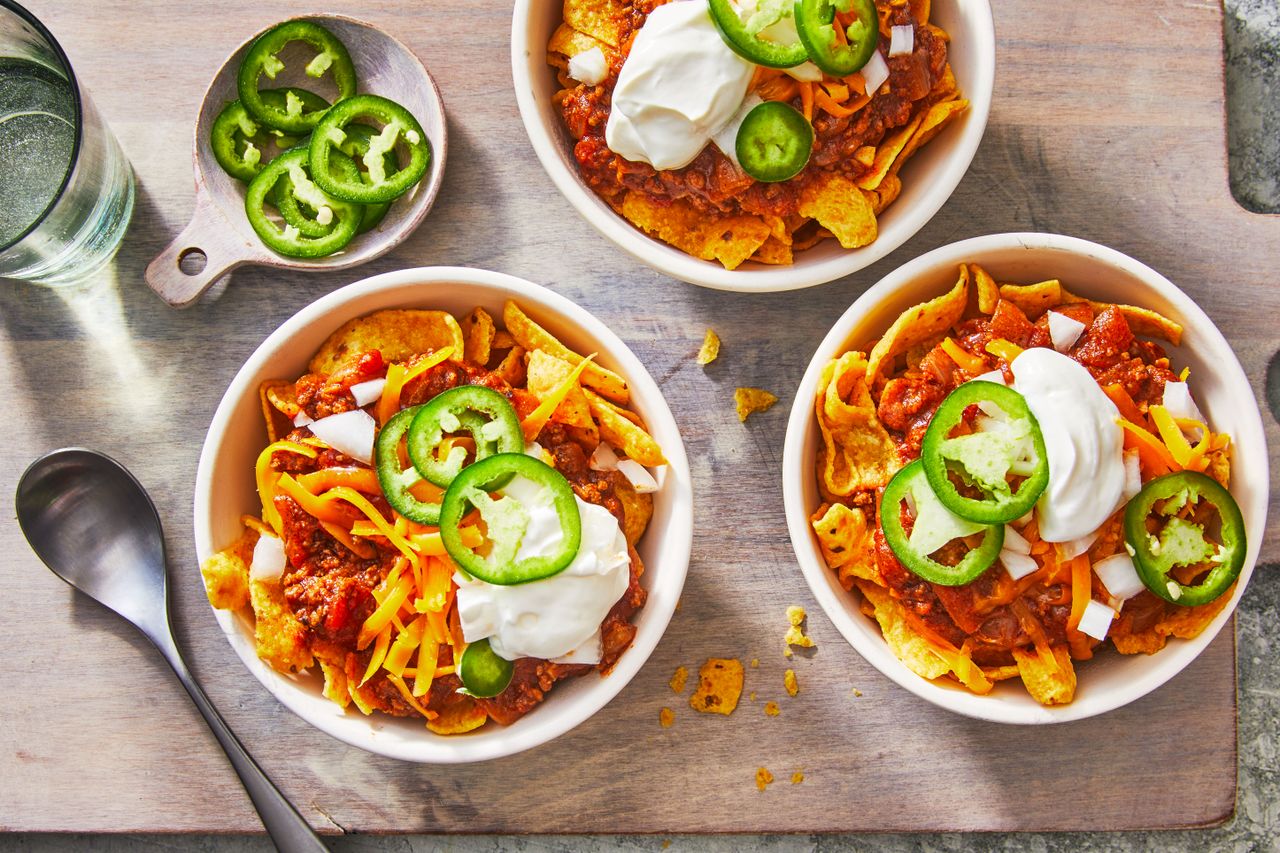 Frito Pie in bowls with sour cream and jalapenos