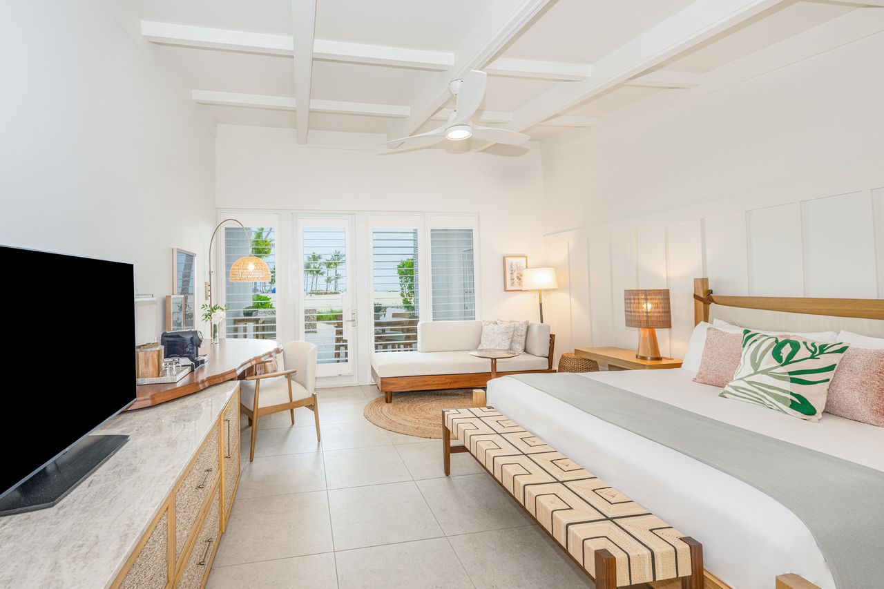 Modern hotel room with a bed seating area and a terrace view