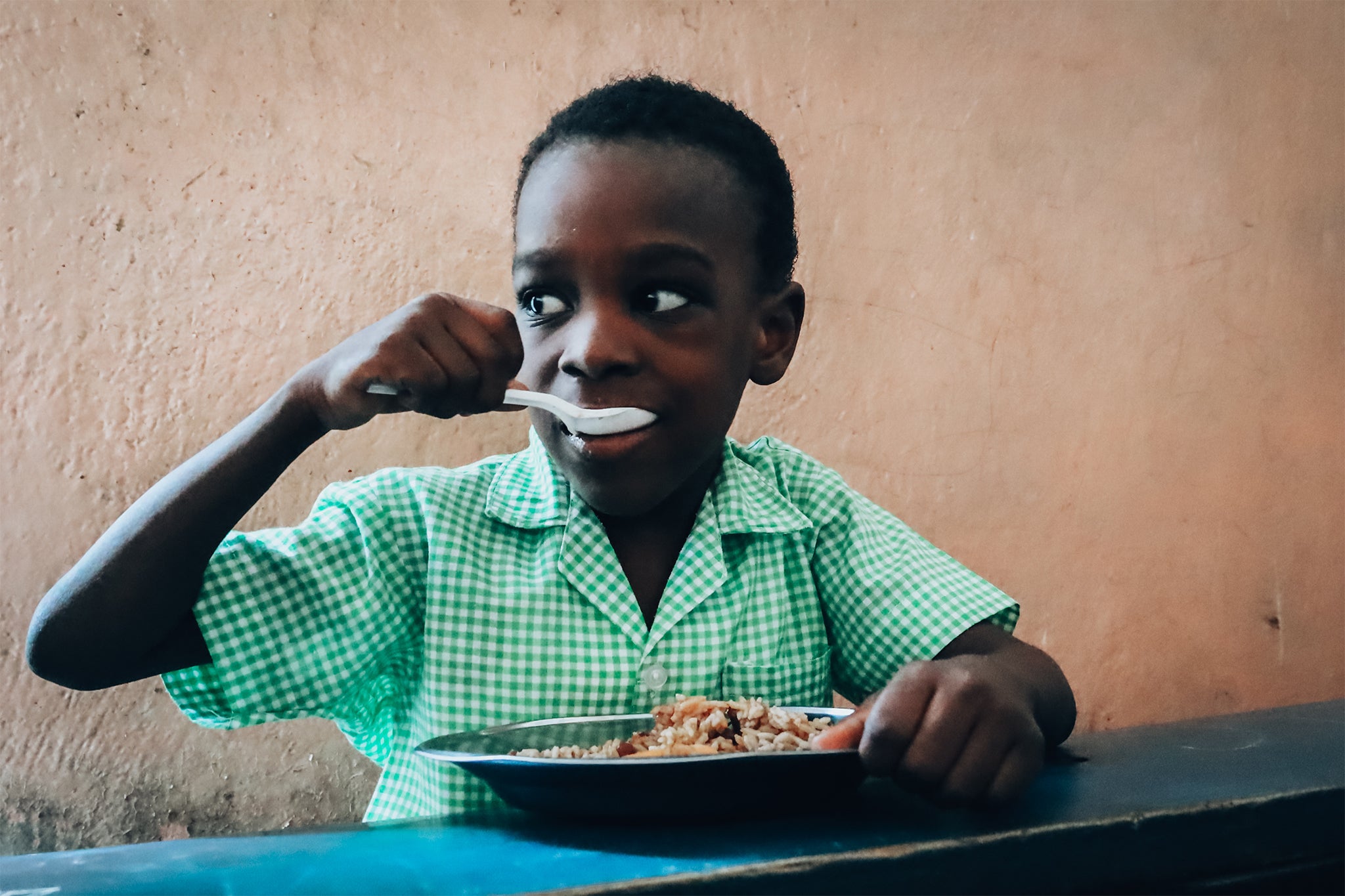 A child eating Mary's Meals at school in Port-au-Prince (Mary's Meals)