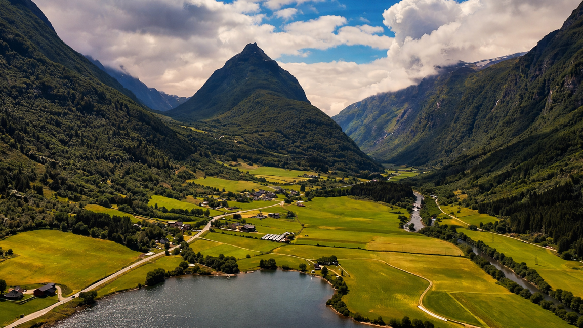 A natural valley landscape with bright fields and towering peaks