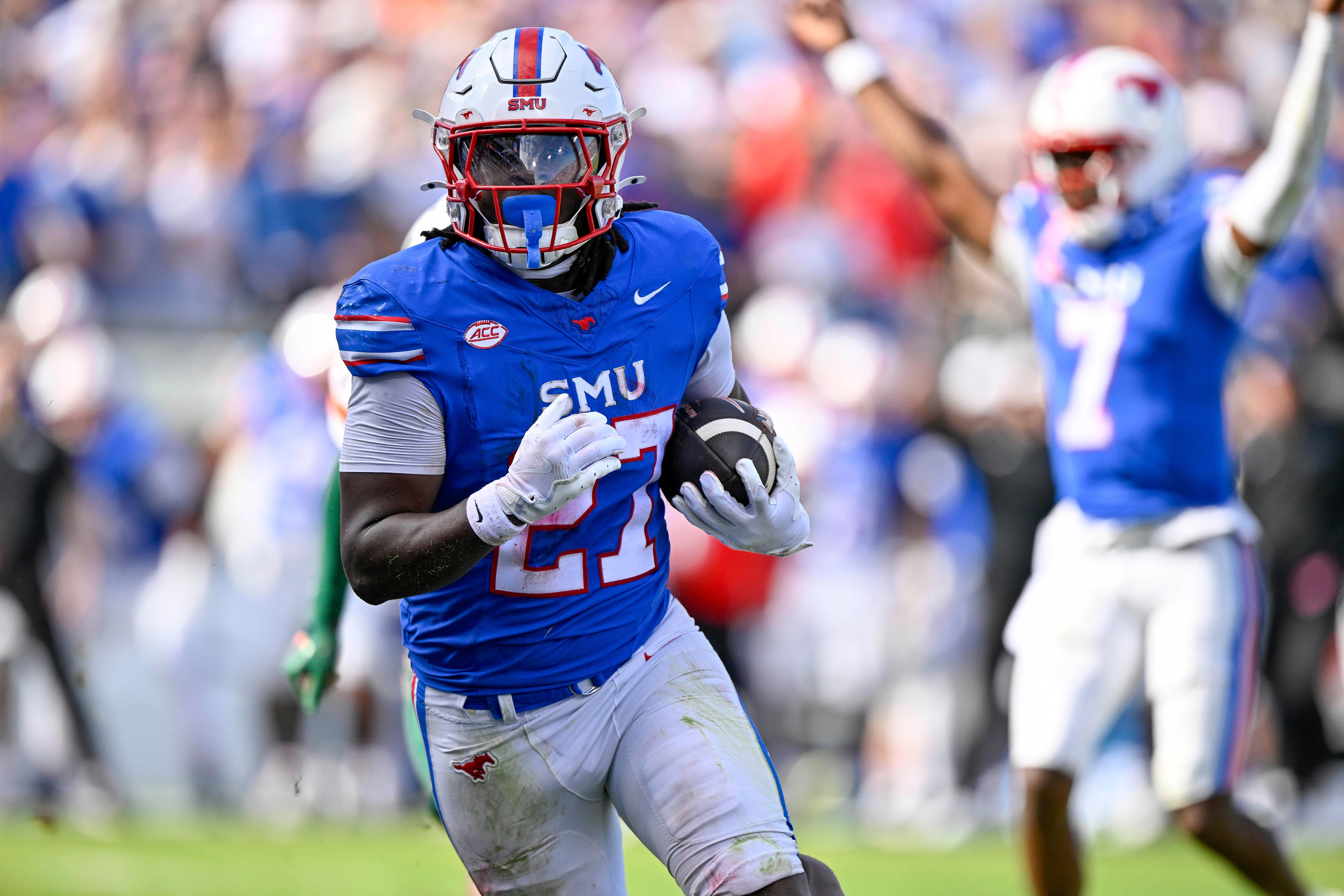 Nov 1, 2025; Dallas, Texas, USA; SMU Mustangs running back T.J. Harden (27) scores the game winning touchdown as quarterback Kevin Jennings (7) celebrates during the overtime period against the Miami Hurricanes at Gerald J. Ford Stadium. Mandatory Credit: Jerome Miron-Imagn Images