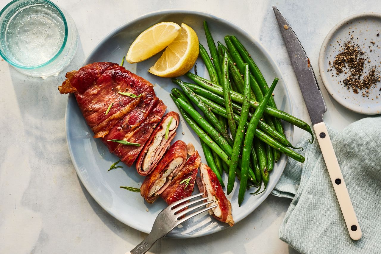 Prosciutto-Wrapped Chicken Cutlets With Haricots Verts on a plate with a glass of water