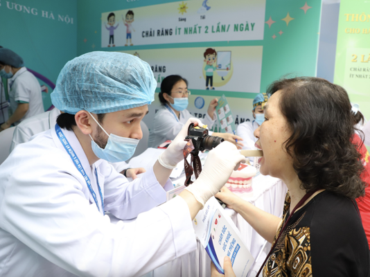 Y bác sĩ Bệnh viện Răng hàm mặt Trung ương kiểm tra răng miệng cho người dân trong Ngày Sức khỏe toàn dân tại Hà Nội - Ảnh: T.MINH