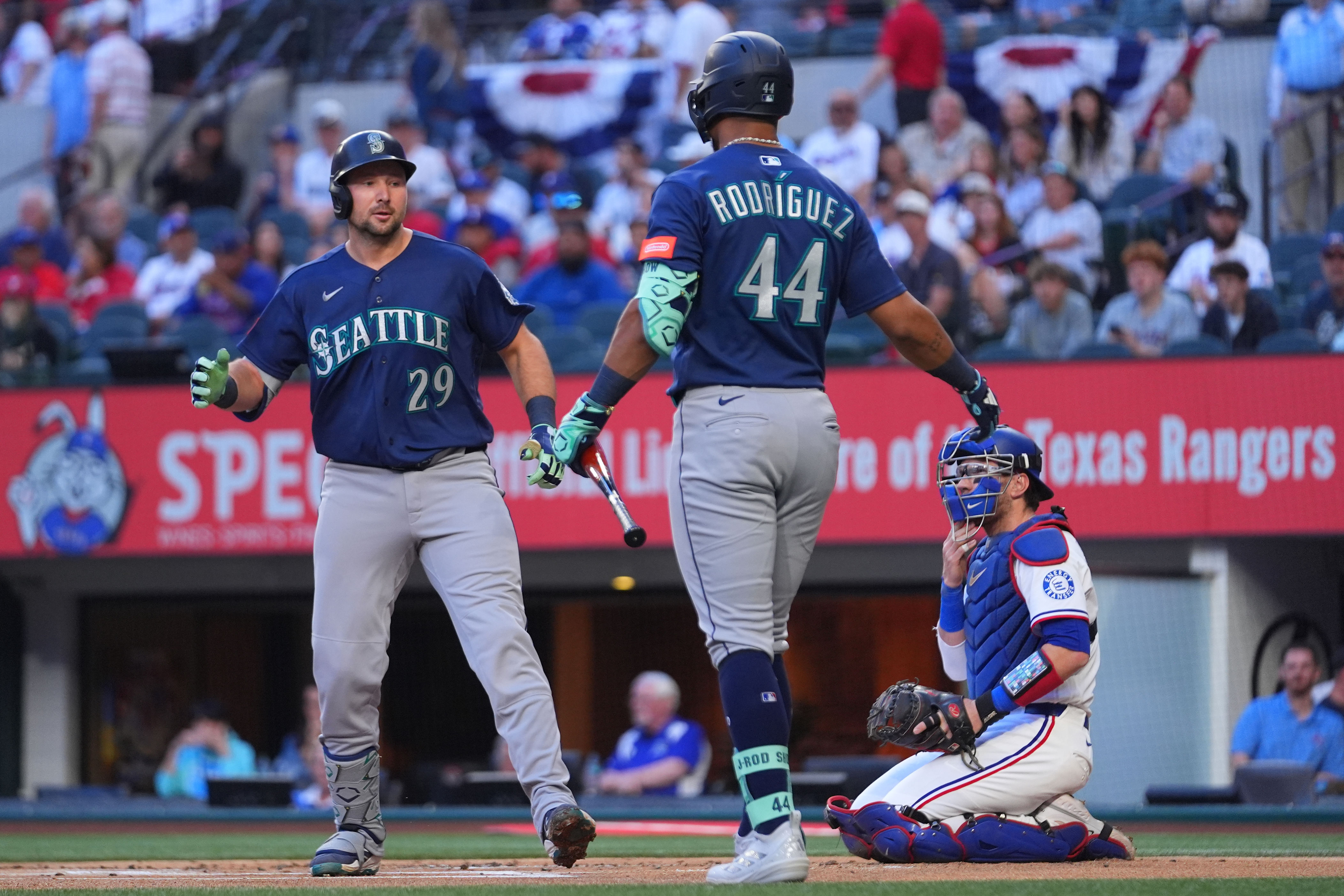 Seattle Mariners' Cal Raleigh (29) is greeted near home plate by Julio Rodr&Igrave;guez (44) after hitting a solo home run off starting pitcher Jacob deGrom during the first inning of a baseball game Monday, April 6, 2026, in Arlington, Texas. (AP Photo/Julio Cortez)