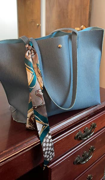 Elegant tote bag on a wooden dresser, accented with a patterned scarf