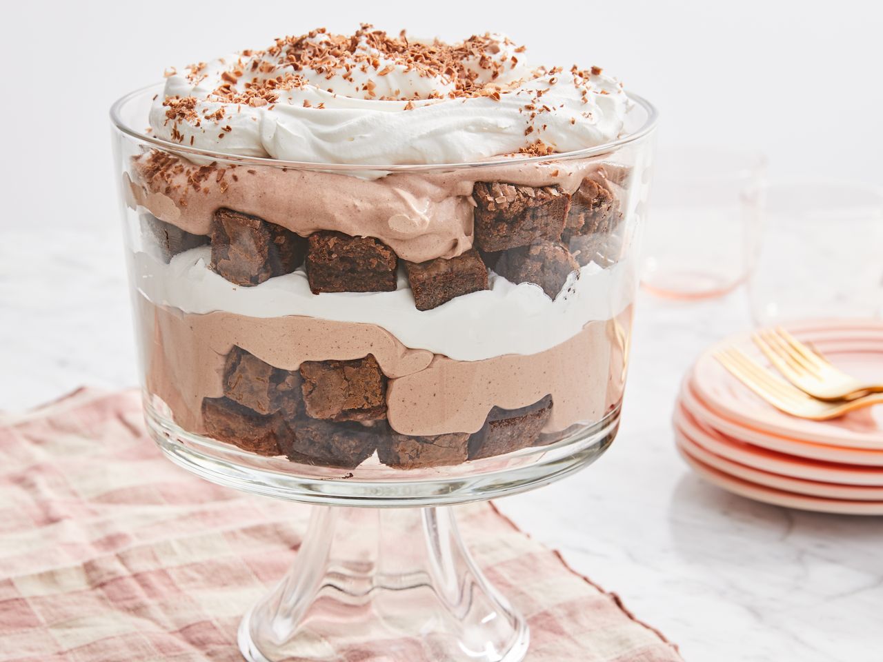 mid angle looking at a chocolate trifle with cream and brownies in a glass trifle bowl