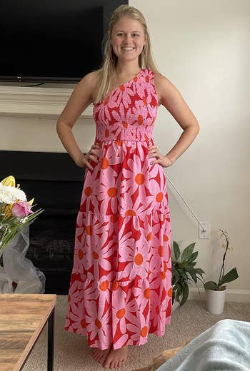 reviewer in red and pink daisy print maxi dress with smocked one shoulder bodice